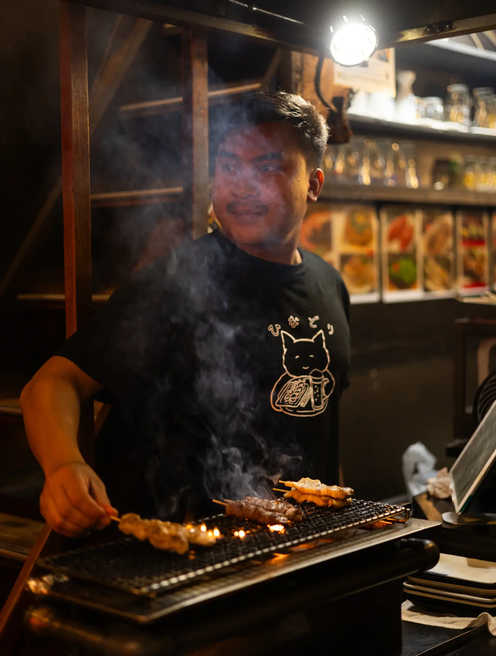 炭火で串を焼く店主